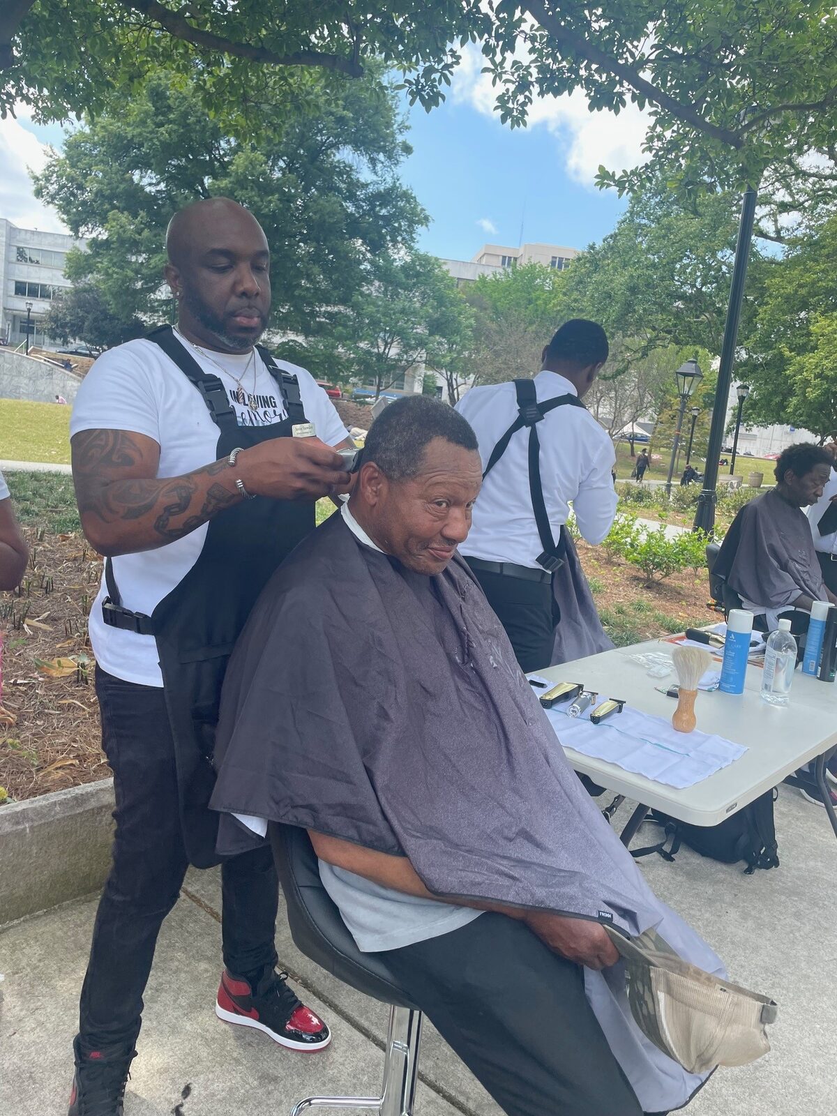 A volunteer barber providing a free haircut